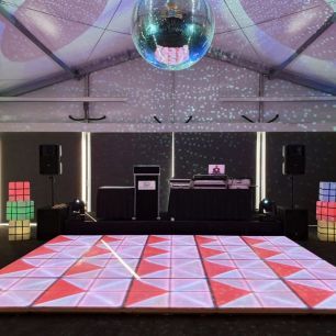 led dancefloor and stage with dj console in a marquee