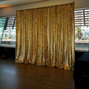 gold metallic drape with fairy lights at party