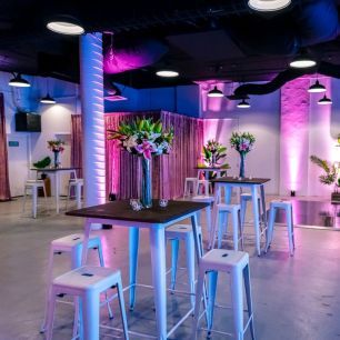 white bar stools in a venue with pink and blue lighting