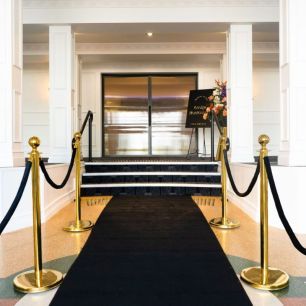 black carpet entrance with gold stanchions