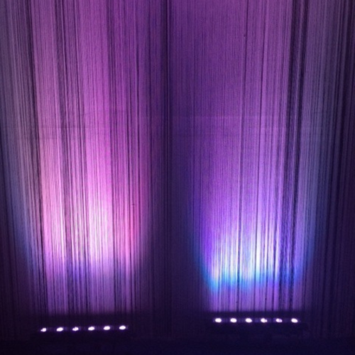 black string curtain with purple uplighting