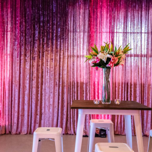 tolix table and bar stools in front of dusty pink velvet crushed drape
