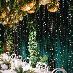 green and gold dinner party with crushed velvet drape and fairy lights