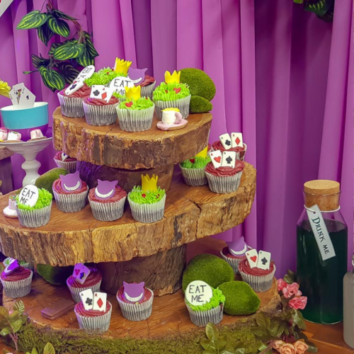 alice in wonderland cupcakes with purple chiffon drape backdrop