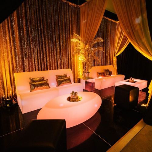 black and gold themed party with straight illuminated sofas