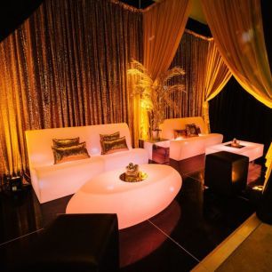 black and gold themed party with oval coffee table and illuminated sofas