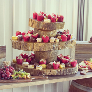 a wooden rustic cake stand filled with sweet food